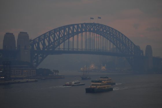 Commuter ferries sail past the Sydney Harbour Bridge as smoke haze from bushfires in New South Wales blankets the CBD in Sydney, Monday, December 2, 2019. (AAP Image/Steven Saphore) NO ARCHIVING