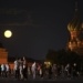 The August Super Blue Moon sets behind a historical building and the St. Basil's Cathedral, right, as people walk in Red Square in Moscow, Russia, Wednesday, Aug. 30, 2023. The cosmic curtain rises Wednesday night with the second full moon of the month, the reason it is considered blue. It is dubbed a supermoon because it is closer to Earth than usual, appearing especially big and bright. (AP Photo/Alexander Zemlianichenko)