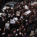 Mourners carry the coffins and pictures of people killed in a rocket strike from Lebanon a day earlier, during a mass funeral in the Druze town of Majdal Shams in the Israel-annexed Golan Heights, on July 28, 2024. The Israeli military said the victims were struck by an Iranian-made rocket carrying a 50-kilogram warhead that was fired by Lebanese Hezbollah group at a soccer field in the Druze Arab town. Hezbollah has denied responsibility for the strike. (Photo by Menahem KAHANA / AFP)